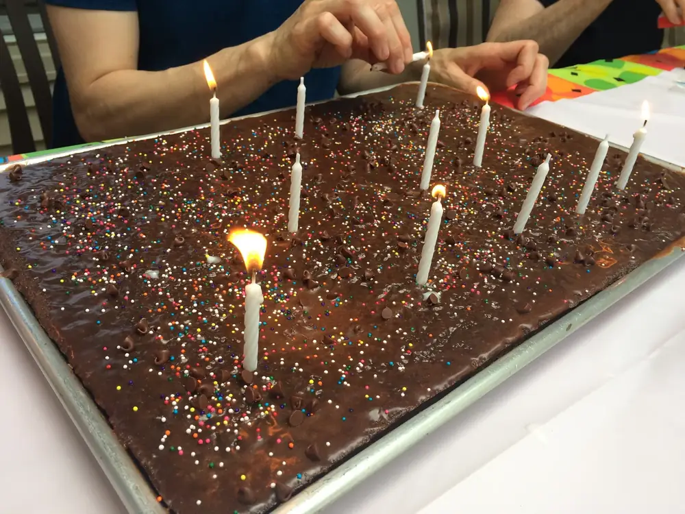 Rectangular chocolate sheet cake with sprinkles and birthday candles
