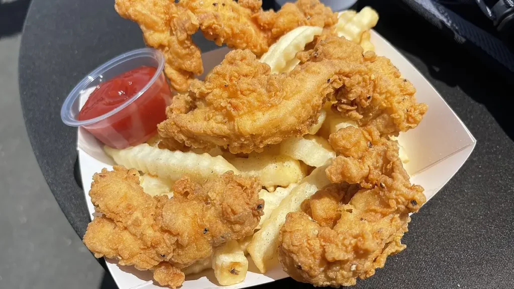 Crispy chicken tenders with crinkle-cut fries and ketchup dipping sauce