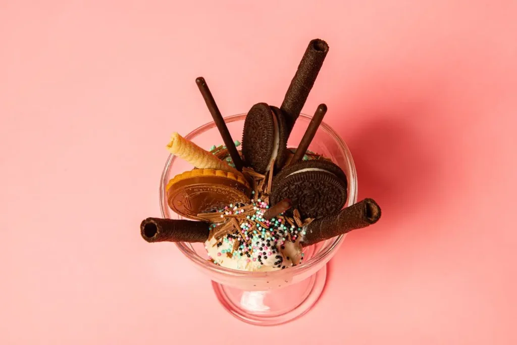 Ice cream sundae with cookies, wafer rolls, and sprinkles