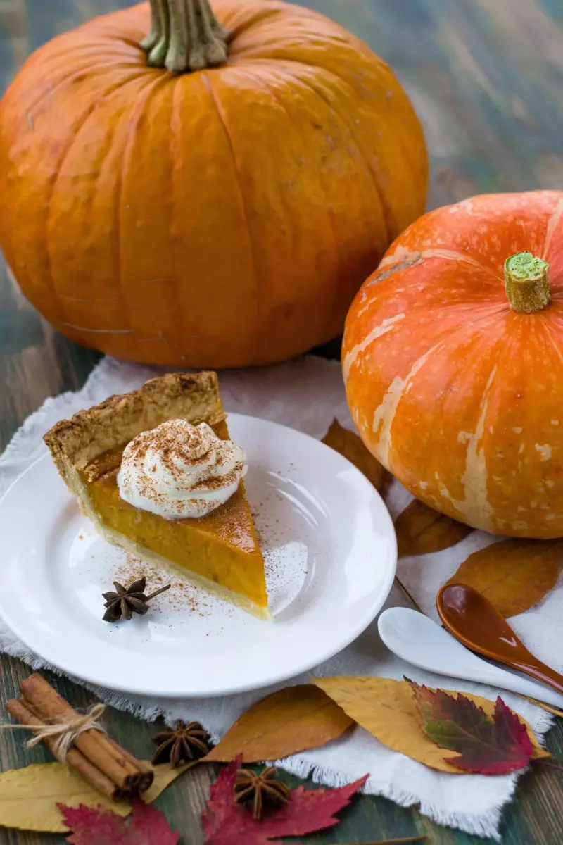 Slice of pumpkin pie topped with whipped cream
