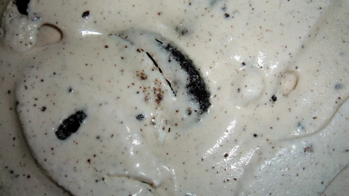 Close-up of creamy white blended frozen dessert with dark cookie pieces mixed throughout